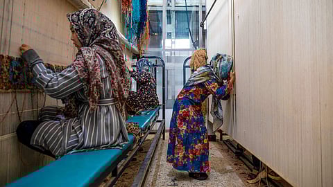 AFGHAN women weave carpets at a factory on the outskirts of Kabul.