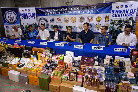 Officials from the National Committee on Intellectual Property Rights present to the media various counterfeit products that were seized during raids at multiple warehouses owned by two malls in Divisoria on Wednesday.