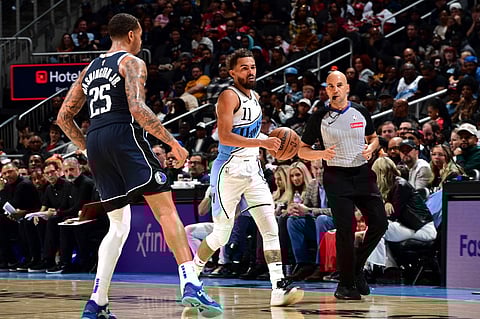 ATLANTA, GA - 25 NOVEMBER: Trae Young #11 of the Atlanta Hawks brings the ball up court during the game against the Dallas Mavericks at State Farm Arena in Atlanta, Georgia. 