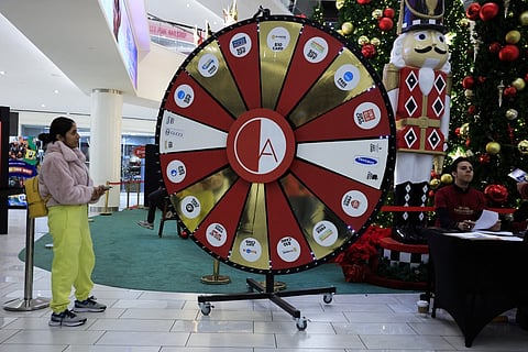 EAST RUTHERFORD, NEW JERSEY - 29 NOVEMBER: A woman take part in a roulette prices game as she visits the American Dream Mall During Black Friday sales in East Rutherford City. Black Friday, is the sales event that is considered the unofficial kickoff of the holiday shopping season and one of the busiest days of the year for retail foot traffic in the U.S. 
