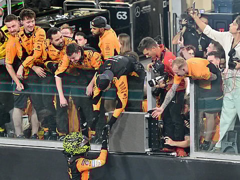 Lando Norris celebrates with the McLaren crew after winning the Abu Dhabi Grand Prix to seal the constructors' title