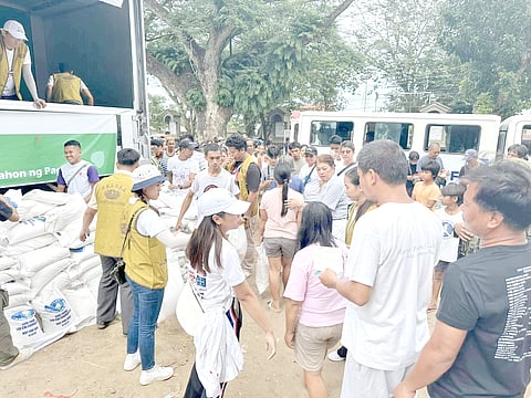 Tzu Chi volunteers distribute rice to survivors of typhoon ‘Kristine’ outside a church in San Roque, Bula, Camarines Sur.