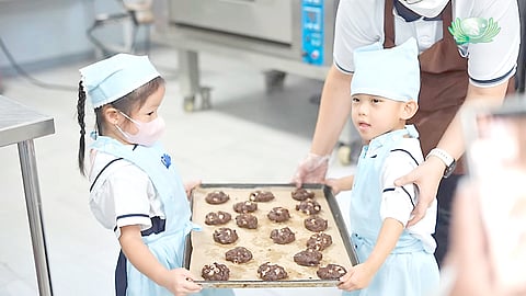Kids show the cookies they baked with help from their parents and Tzu Chi volunteers.