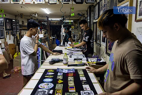 Staff members at a picture frame shop in Quiapo, Manila, work together to complete various frames on Monday, 16 December 2024, ahead of the holiday rush.
