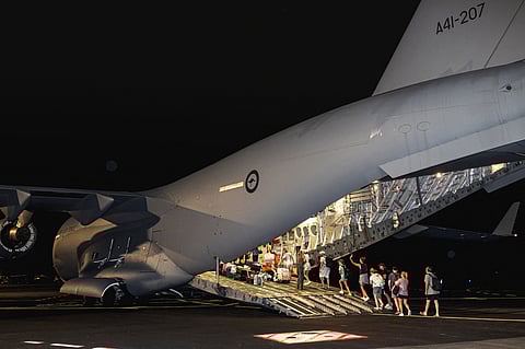 AUSTRALIAN citizens board a Royal Australian Air Force C-17A transport aircraft at Bauerfield International Airport in Port Vila, for a repatriation flight following the Vanuatu earthquake. Foreign rescuers joined a hunt for survivors in the rubble of shattered buildings, with officials saying the toll of nine dead is set to rise. 