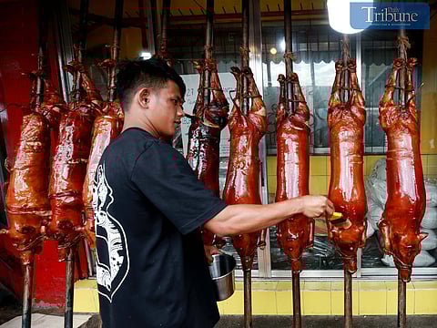 Workers prepare delicious lechon baboy (roasted pig) at various stores in La Loma, Quezon City, on Sunday, 22 December, 2024. Lechon remains a popular choice for Noche Buena, the traditional Christmas Eve feast. 