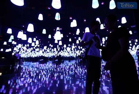 Visitors take photos and selfies at the "Secret of Lights" exhibit while exploring various 3D art installations and festive Christmas displays at Art in Island, Quezon City, on Monday, 23 December 2024, just a day before Christmas Eve.