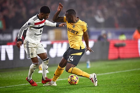 Manchester United's Ivorian midfielder #16 Amad Diallo battles for the ball with Wolverhampton Wanderers' Portuguese defender #24 Tote Gomes during the English Premier League football match between Wolverhampton Wanderers and Manchester United at the Molineux stadium in Wolverhampton, central England on 26 December, 2024.
