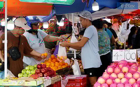 On Monday, 30 December 2024, a fruit vendor assists customers buying round fruits along Commonwealth Avenue, Quezon City, in preparation for New Year's celebrations. In Filipino tradition, 12 round fruits symbolize luck and prosperity for the coming year.