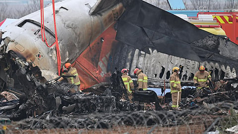 Firefighters and recovery teams work at the site of the Jeju Air crash at Muan International Airport. 
