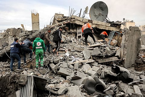 People and rescue workers inspect the rubble of a residential building that collapsed after an Israeli airstrike in the Saraya neighborhood of al-Rimal, central Gaza City, on Jan. 4, 2025, as the war between Israel and Hamas continues in the Palestinian territory. 
