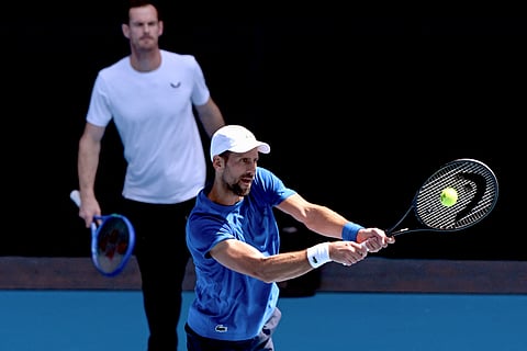 Serbia's Novak Djokovic (R) hits a return as coach Andy Murray looks on during a training session ahead of the Australian Open tennis tournament in Melbourne on January 9, 2025.
William WEST / AFP