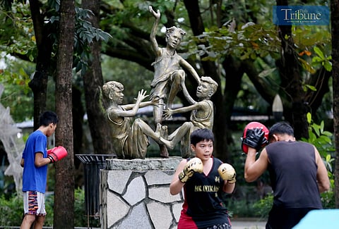 On Saturday, 11 January, 2025, a sculpture depicting children playing the traditional Filipino game "luksong tinik" was on display at Quezon City Memorial Circle, as a group nearby practiced boxing.