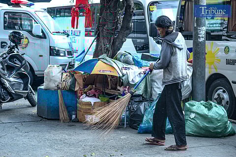 A woman cleans up her space with her dog by her side along Taft Avenue as vehicles part of the National Rally for Peace surround the area on 13 January, 2025.