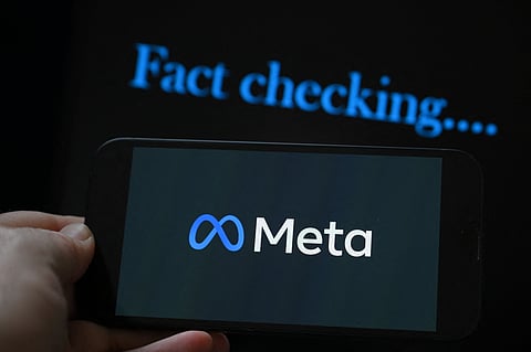 (FILES) This photo illustration created on 8 January 2025, in Brussels, shows the media giant Meta's logo displayed on a smartphone and screen displaying the words "fact checking". Brazil on 10 January 2025, gave social media giant Meta 72 hours to explain its fact-checking policy for the country, and how it plans to protect "fundamental rights" on its platforms. Attorney General Jorge Messias told journalists his office could take "legal and judicial" measures against Meta if it does not respond in time to an extrajudicial notice filed Friday.