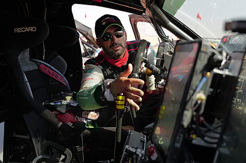 Yazeed al-Rajhi checks his car as he waits at the start of Stage 11 of the Dakar Rally 2025.