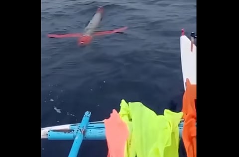 Screenshot of the silver and red drone caught on video drifting near a fishing vessel.