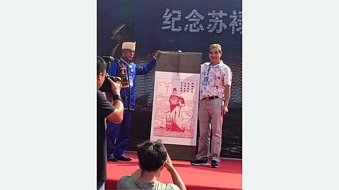35th Sultan Phugdalun Kiram II, with the descendant of the East King of Sulu, holds a picture of the East King of Sulu during the 600th Year Commemoration of the Death Anniversary of the East King of Sulu in Dezhou City, Shandong Province, China.
