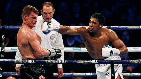 Russia's Alexander Povetkin (2nd L) falls backward as Britain's Anthony Joshua (R) throws a punch to knock him to the canvas in the 7th round during their boxing world Heavyweight title fight at Wembley Stadium in northwest London on 22 September 2018. Britain's Anthony Joshua retained his International Boxing Federation, World Boxing Association, and World Boxing Organisation heavyweight titles with a seventh-round stoppage of Alexander Povetkin at London's Wembley Stadium on 22 September 2018.
