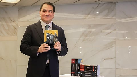 DivinaLaw Managing Partner Dean Nilo Divina holding a copy of the 2025 Divina Compendious Bar Review Series