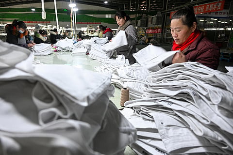 Employees produce clothing at a garment factory which exports to Europe and the US in Suqian, Jiangsu province 