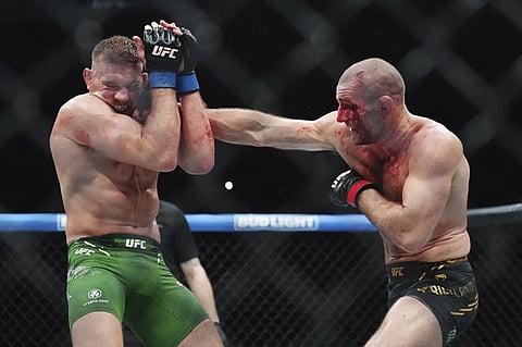 Sean Strickland, right, hits Dricus Du Plessis during a middleweight title bout during the UFC 297 mixed martial arts event in Toronto, Jan. 21, 2024. 