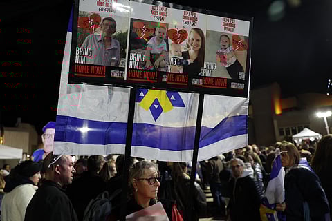 People carry a placard bearing the pictures of Oded Lifshitz and members of the Bibas family, hours after the Palestinian group Hamas handed over the bodies of who it said were those of the four hostages, on 20 February 20, 2025. A minute of silence took place at the start of a rally in solidarity with the families of the dead hostages, who Hamas say include three members of the Bibas family, who have become symbols of the hostage crisis that has gripped Israel since the Gaza war broke out.
