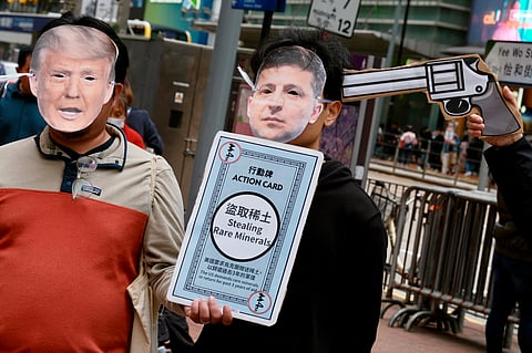 Activists wearing masks of US President Donald Trump (L) and Ukrainian President Volodymyr Zelensky take part in a demonstration in Hong Kong's Causeway Bay district on 23 February 2025, ahead of the third anniversary of Russia’s invasion of Ukraine. The activists said during a brief public demonstration that Russian leader Vladimir Putin must be held responsible, adding that they opposed US President Donald Trump’s "hijacking" of peace talks.