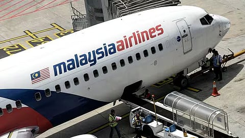 Malaysia Airlines ground staff walk on the tarmac next to a Malaysia Airlines plane at Kuala Lumpur International Airport in Sepang on February 25, 2016. A fresh search for Malaysia Airlines flight MH370 has been launched more than a decade after the plane went missing in one of aviation’s greatest enduring mysteries, with maritime exploration firm Ocean Infinity resuming the hunt for the missing plane, according to Malaysian transport minister Anthony Loke on February 25, 2025. 