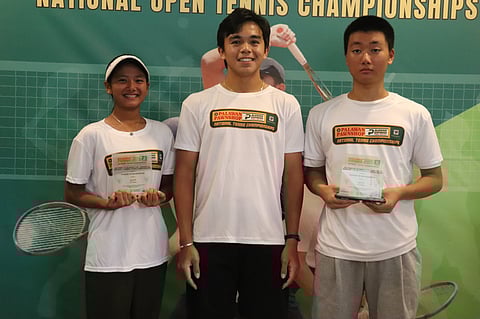 Jonathan Higa (right) and Cadee Dagoon (left) smile as they display their trophies with Eric Jed Olivarez Jr. during awards rites of the Olivarez National Junior Tennis Championships.