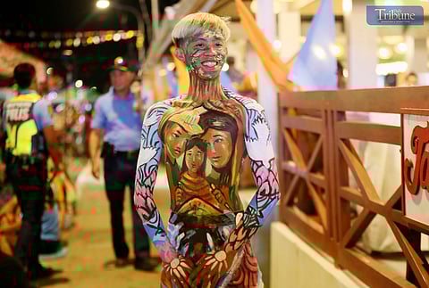On Sunday night, 2 February 2025, participants in colorful body paint showcase their designs during the judging of the Pinta Tawo competition, part of the 52nd Iloilo-Guimaras Paraw Regatta Festival in Iloilo City.
