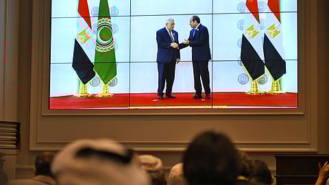 People watch on a big screen as Egypt's president, Abdel Fattah al-Sisi (right) welcomes the Palestinian president, Mahmoud Abbas, before an Arab League summit in Cairo.
