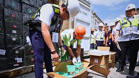 Officials from the Bureau of Customs inspect the boxes loaded with unregistered vapes which were misdeclared as insulated cups at the Port of Manila recently.