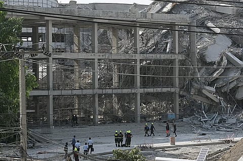 Rescue workers look at the debris of a construction site after a building collapsed in Bangkok on March 28, 2025, following an earthquake. A powerful earthquake rocked central Myanmar on March 28, buckling roads in capital Naypyidaw, damaging buildings and forcing people to flee into the streets in neighbouring 
