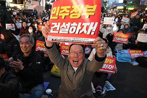 ANTI-YOON protesters display placards reading ‘Let’s build a democratic government!’ during a rally in Seoul on Friday following the Constitutional Court’s ruling to uphold the impeachment of South Korean President Yoon Suk Yeol.