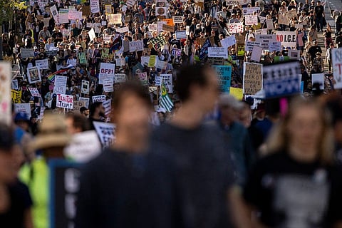 Protesters hold signs during the nationwide "Hands Off!" protest against Trump and his advisor, Tesla CEO Elon Musk, in downtown Los Angeles on April 5, 2025. Protesters flooded the streets of several major US cities on Saturday to oppose the divisive policies of President Donald Trump, in the largest demonstrations since his return to the White House. Opponents of the Republican president's policies -- from government staffing cuts to trade tariffs and eroding civil liberties -- rallied in Washington, New York, Houston, Los Angeles and Florida, among other locations. 