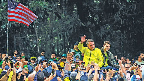 (FILES) Brazil’s former president Jair Bolsonaro greets supporters next to his son Renan during a rally at Paulista Avenue in Sao Paulo, Brazil.