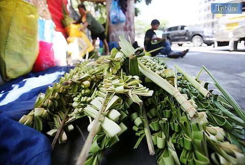 Evelyn Copper from Laguna weaves palm leaves, or palaspas, to sell for Palm Sunday in front of Santo Domingo Church — National Shrine of Our Lady of the Holy Rosary of La Naval de Manila — on Thursday, 10 April. The faithful will mark Palm Sunday on 13 April.