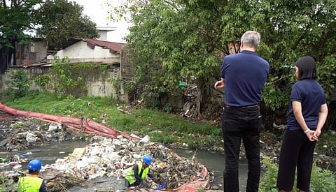 RiverRecycle Founder and CEO Anssi Mikola and Prime Infra's Cara Peralta inspect clean-up efforts at Kinalumsan River, where a boom prevents waste leakage and plastics are manually collected from the water.
