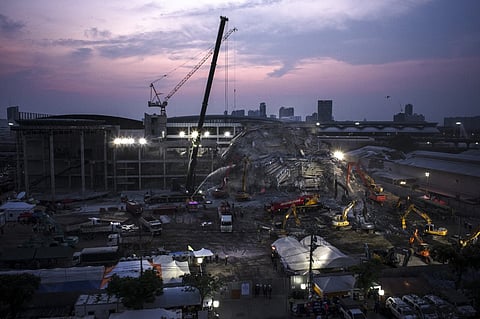 (FILES) The sun sets over the site of an under-construction building collapse as rescue personnel work to find any survivors trapped in the rubble in Bangkok on 2 April 2025, five days after an earthquake struck central Myanmar and Thailand. Thai authorities said they had arrested a Chinese executive at a company that was building a Bangkok skyscraper before it collapsed in a devastating earthquake in neighboring Myanmar.
