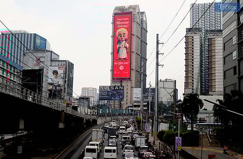A cartoonized photo of Pope Francis is seen displayed on an electronic billboard along EDSA in Mandaluyong on Wednesday, 23 April 2025, two days after his passing at age 88. Remembered for his populist approach and efforts to reach people from all walks of life, Pope Francis leaves behind a legacy of compassion, humility, and dialogue.