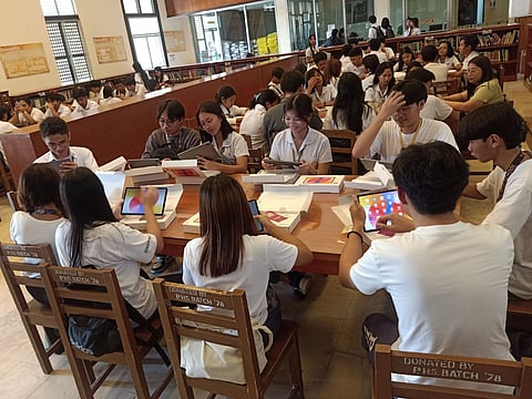Students of Pampanga High School try the AI-enabled tablets pre-loaded with DTP e-modules donated by Globe.