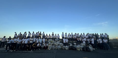 Volunteers from SM Supermalls — including employees, customer relations staff, and janitorial personnel — come together after a successful coastal cleanup at SM By the Bay.
