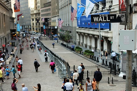 Pedestrians walk in front of the New York Stock Exchange. The United States lost its last triple-A credit rating from a major agency Friday as Moody’s announced a downgrade, citing rising levels of government debt. The downgrade to Aa1 from Aaa adds to the bad news for the US president, coming on the same day his flagship spending bill failed to pass a key vote in Congress.