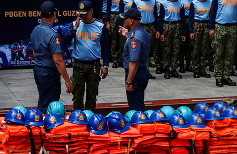 Officials from the Manila Police District present the rescue gear which include life vests, helmets and cutting tools during the Philippine National Police’s annual inspection of disaster response equipment at the MPD headquarters in Manila on Wednesday. 
