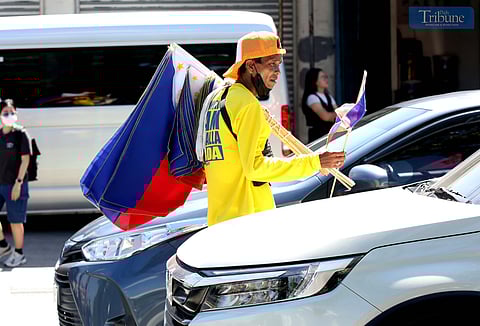 Vendors sell Philippine flags of various sizes to motorists along Commonwealth Avenue in Quezon City on Friday. The country will mark Philippine Flag Day on 28 May, commemorating the flag’s first unfurling in battle during the 1898 Battle of Alapan in Imus, Cavite, shortly before the declaration of independence from Spanish rule.