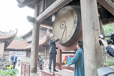 France’s President Emmanuel Macron hits the drum as he visits the Temple of Literature in Hanoi.