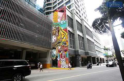 A giant mural (Mac & Qis) by Filipino-Canadian artist Sowl at a building in Eastwood City in Quezon City. The mural was inspired by Philippine indigenous textiles and baybayin, and aims to heal and revive the weary souls of those who stop to appreciate it.