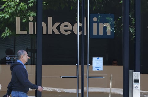 A PEDESTRIAN walks by a sign at a LinkedIn office on July 26, 2023 in San Francisco, California. LinkedIn announced plans to cut nearly 200 jobs at offices in the San Francisco Bay Area. The cuts follow 700 layoffs earlier in the year.