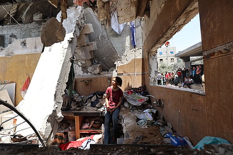 A child stands in the rubble of a house targeted in an Israeli strike in the Nuseirat camp for Palestinian refugees in the central Gaza Strip.
